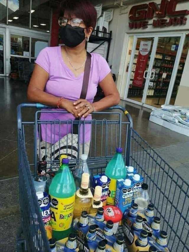 Señora saliendo del super con el carrito lleno de bebidas alcoholicas y refrescos