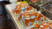 Camarones servidos sobre latas de cerveza